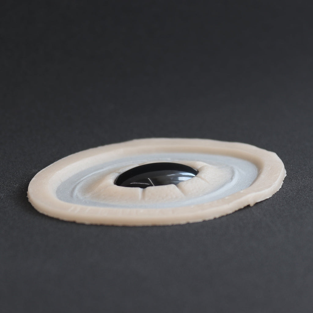 Gem - Silicone makeup prosthetic in vanilla shade on a black surface