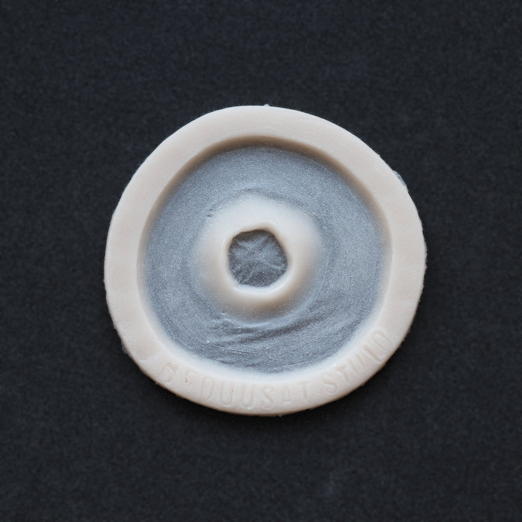 Gunshot Entry Wound - Silicone makeup prosthetic in vanilla shade on a black surface