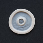 Gunshot Entry Wound - Silicone makeup prosthetic in vanilla shade on a black surface