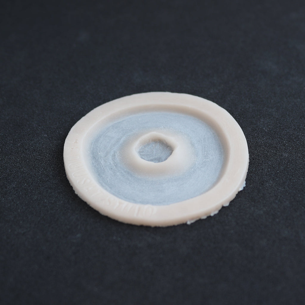 Gunshot Entry Wound - Silicone makeup prosthetic in vanilla shade on a black surface