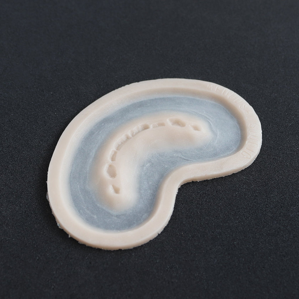 Half Bite - Silicone makeup prosthetic in vanilla shade on a black surface