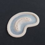 Half Bite - Silicone makeup prosthetic in vanilla shade on a black surface