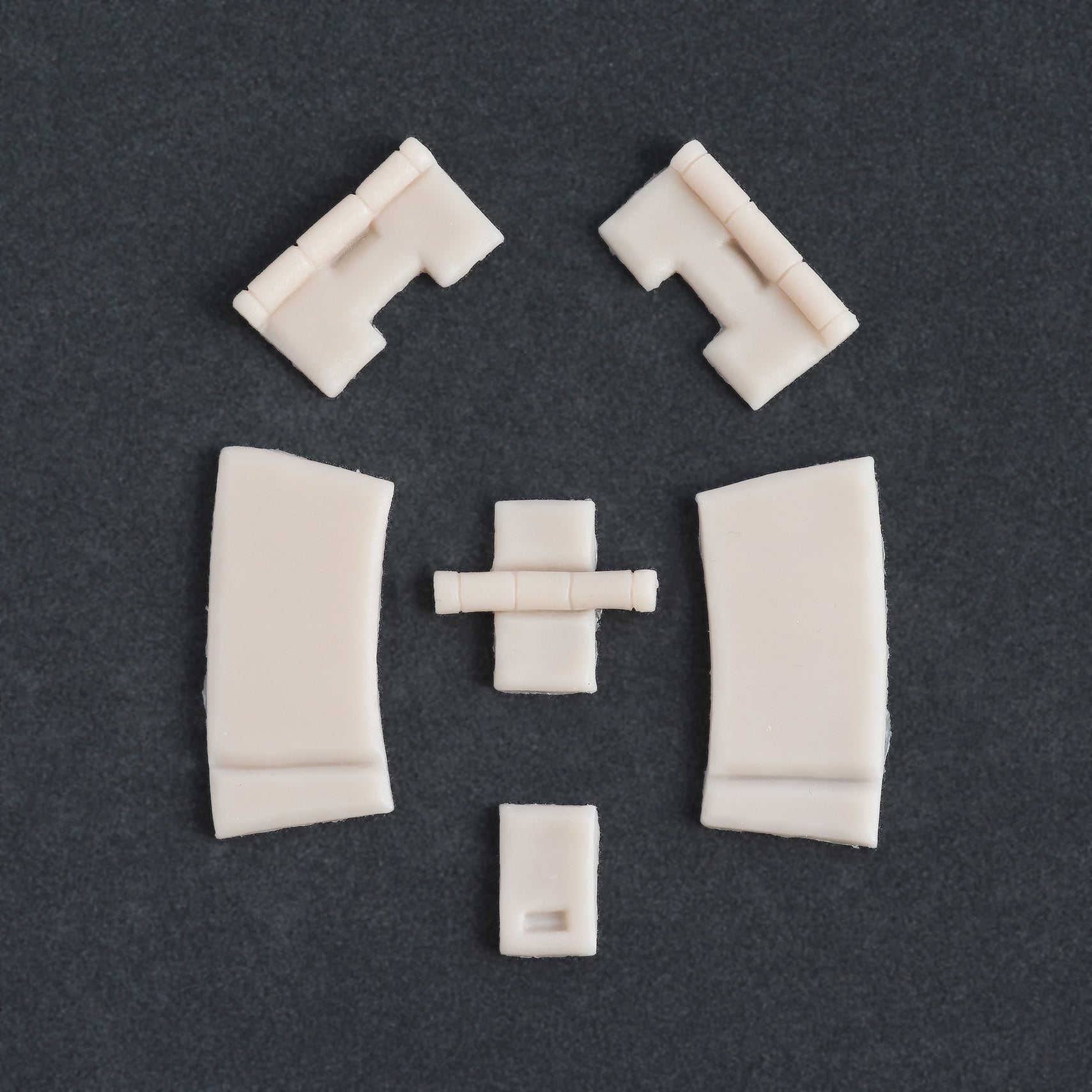 Hinges - Silicone makeup prosthetic in vanilla shade on a black surface