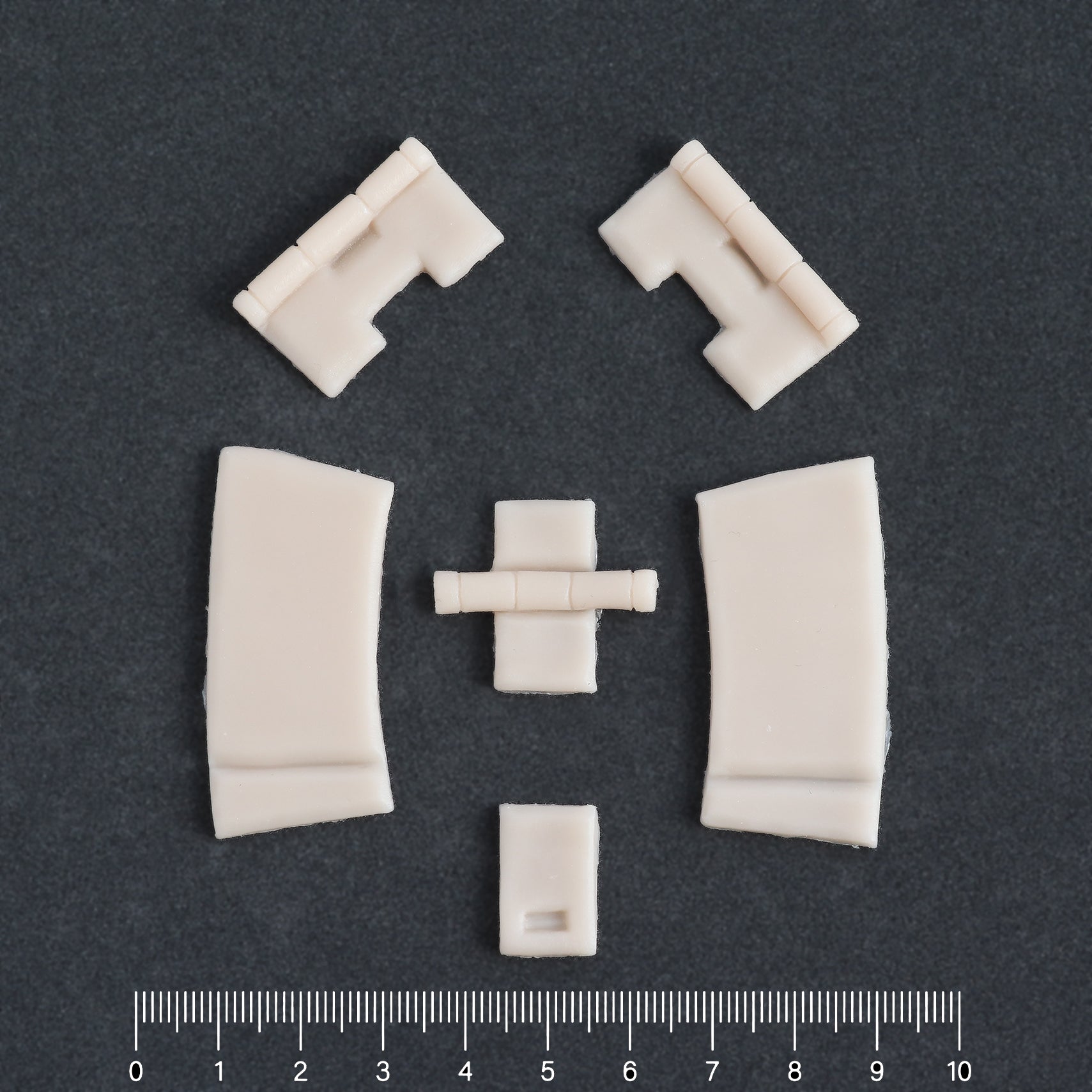 Hinges - Silicone makeup prosthetic in vanilla shade on a black surface with a ruler