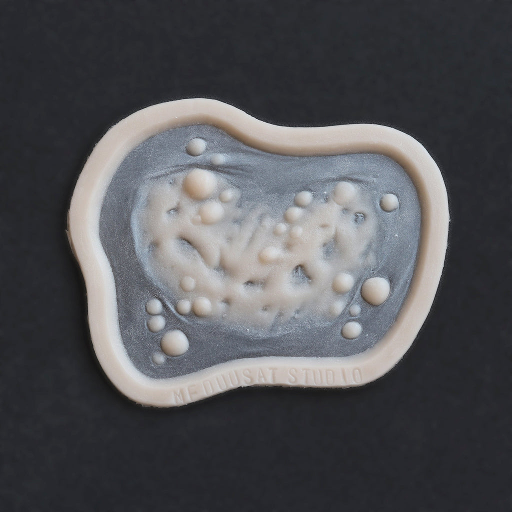 Infected Bite - Silicone makeup prosthetic in vanilla shade on a black surface