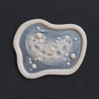 Infected Bite - Silicone makeup prosthetic in vanilla shade on a black surface