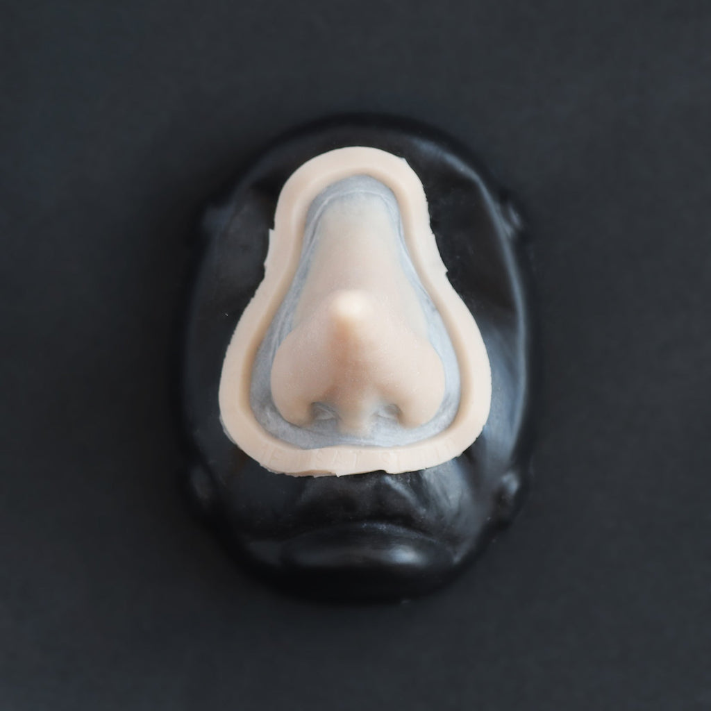 Long Pointy Nose - Silicone makeup prosthetic in vanilla shade on a black surface
