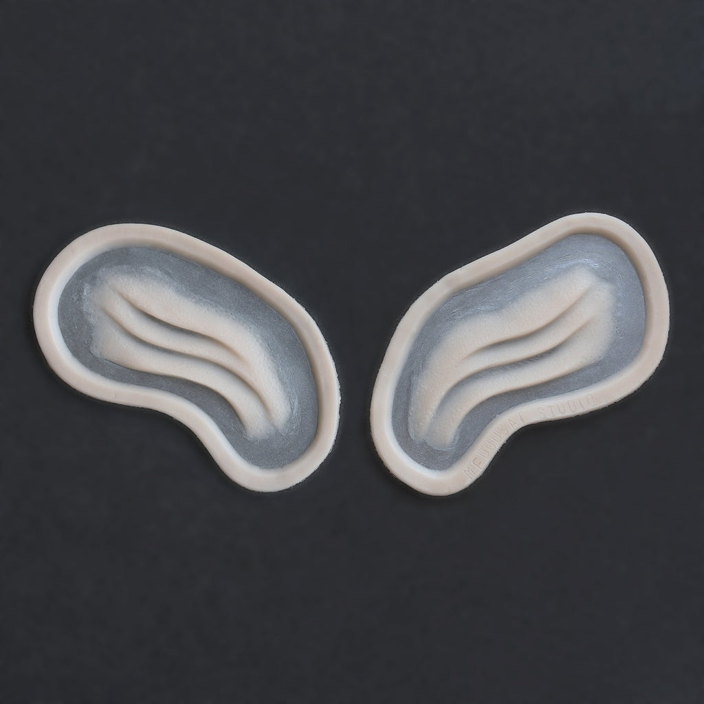 Manta Gills (Pair) - Silicone makeup prosthetic in vanilla shade on a black surface