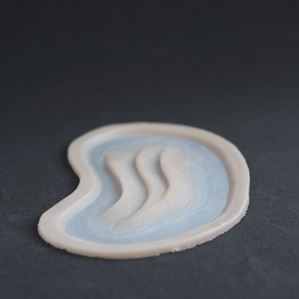 Manta Gills (Pair) - Silicone makeup prosthetic in vanilla shade on a black surface