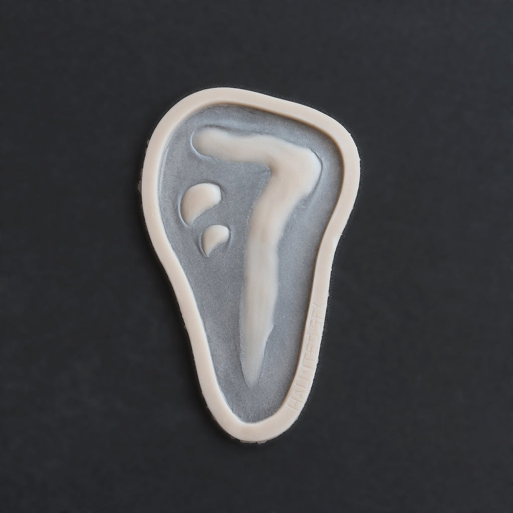 Mark of Cain - Silicone makeup prosthetic in vanilla shade on a black surface