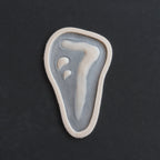 Mark of Cain - Silicone makeup prosthetic in vanilla shade on a black surface