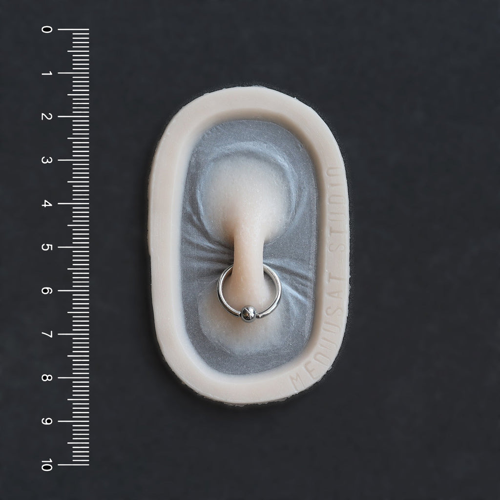 Nose Bridge - Silicone makeup prosthetic in vanilla shade on a black surface with a ruler