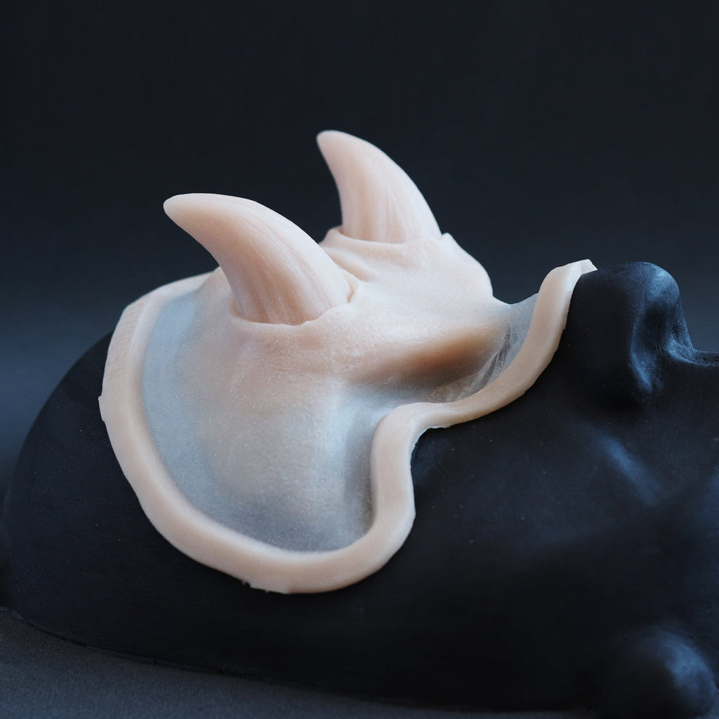 Oni Brow silicone prosthetic in vanilla shade on a black surface at an angle