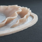 Ruffle Gills (Pair) - Silicone makeup prosthetic in vanilla shade on a black surface