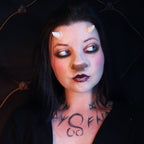 Woman with black hair wearing crooked horns and a satyr nose prosthetic