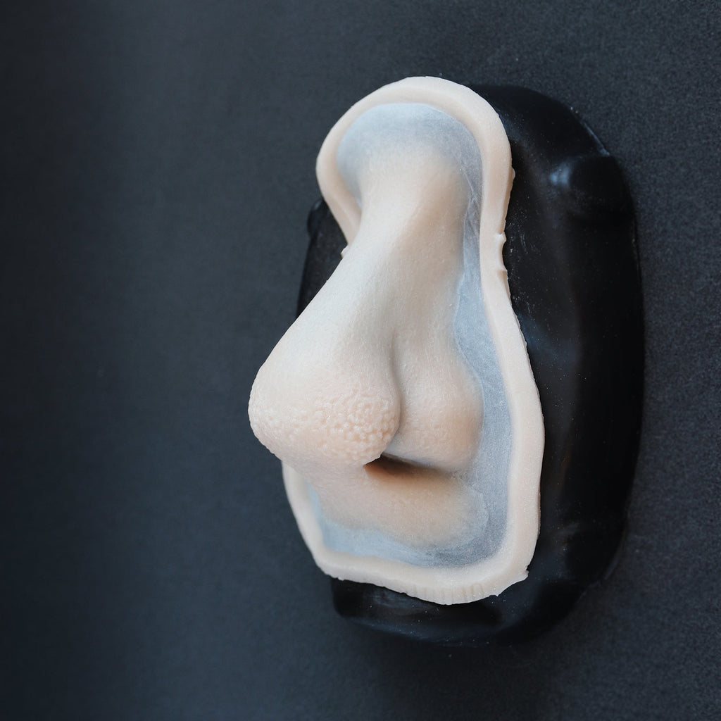 Satyr Nose - Silicone makeup prosthetic in vanilla shade on a black surface