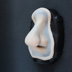 Satyr Nose - Silicone makeup prosthetic in vanilla shade on a black surface