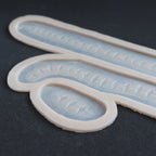 Scarification Strips - Silicone makeup prosthetic in vanilla shade on a black surface