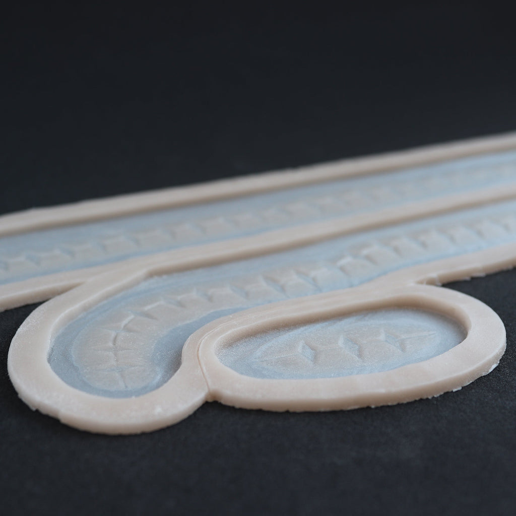 Scarification Strips - Silicone makeup prosthetic in vanilla shade on a black surface