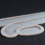 Scarification Strips - Silicone makeup prosthetic in vanilla shade on a black surface