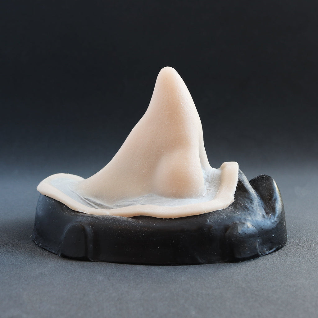 Short Pointy Nose - Silicone makeup prosthetic in vanilla shade on a black surface
