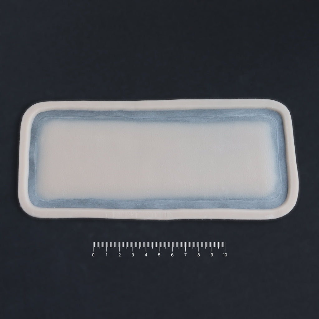 Long Silicone Patch - Silicone makeup prosthetic in vanilla shade on a black surface with a ruler