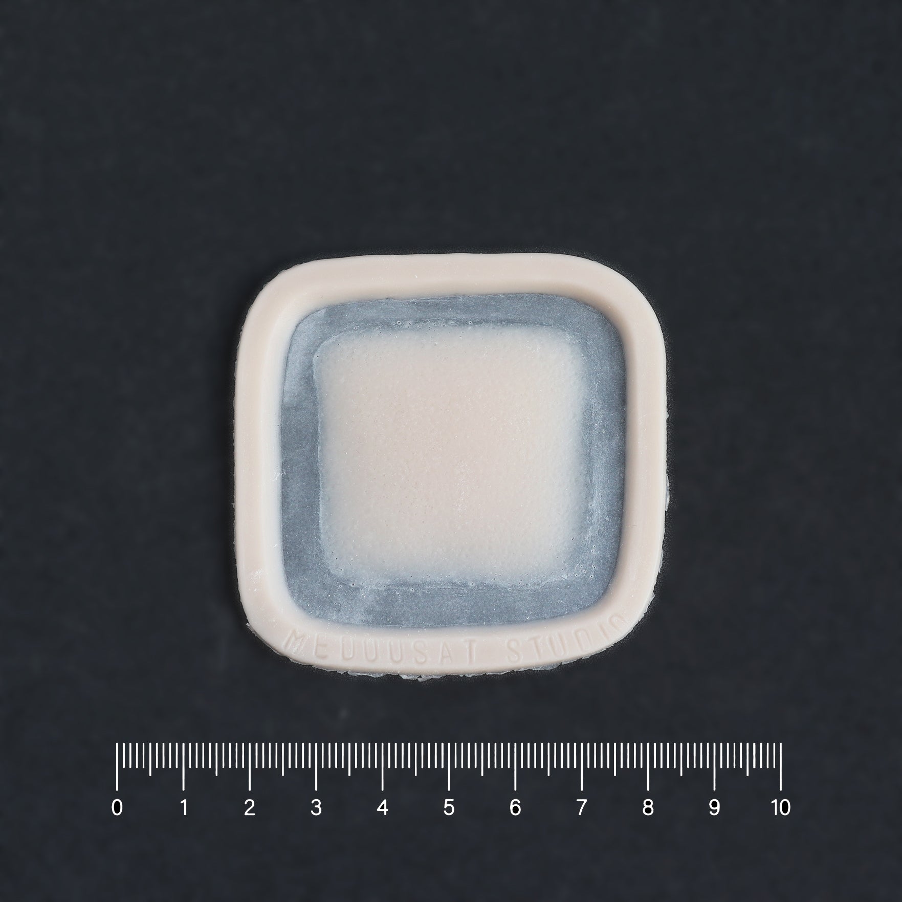 Mini Silicone Patch - Silicone makeup prosthetic in vanilla shade on a black surface with a ruler