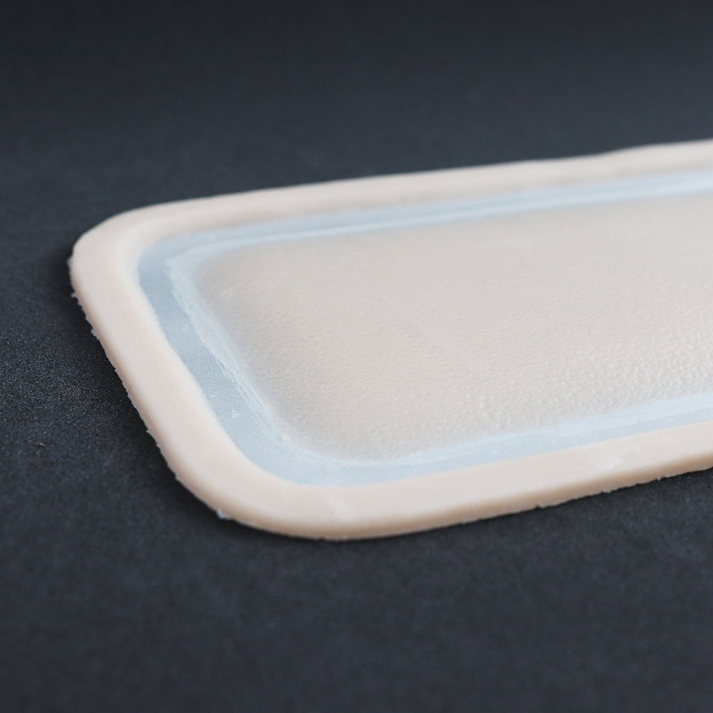 Long Silicone Patch - Silicone makeup prosthetic in vanilla shade on a black surface