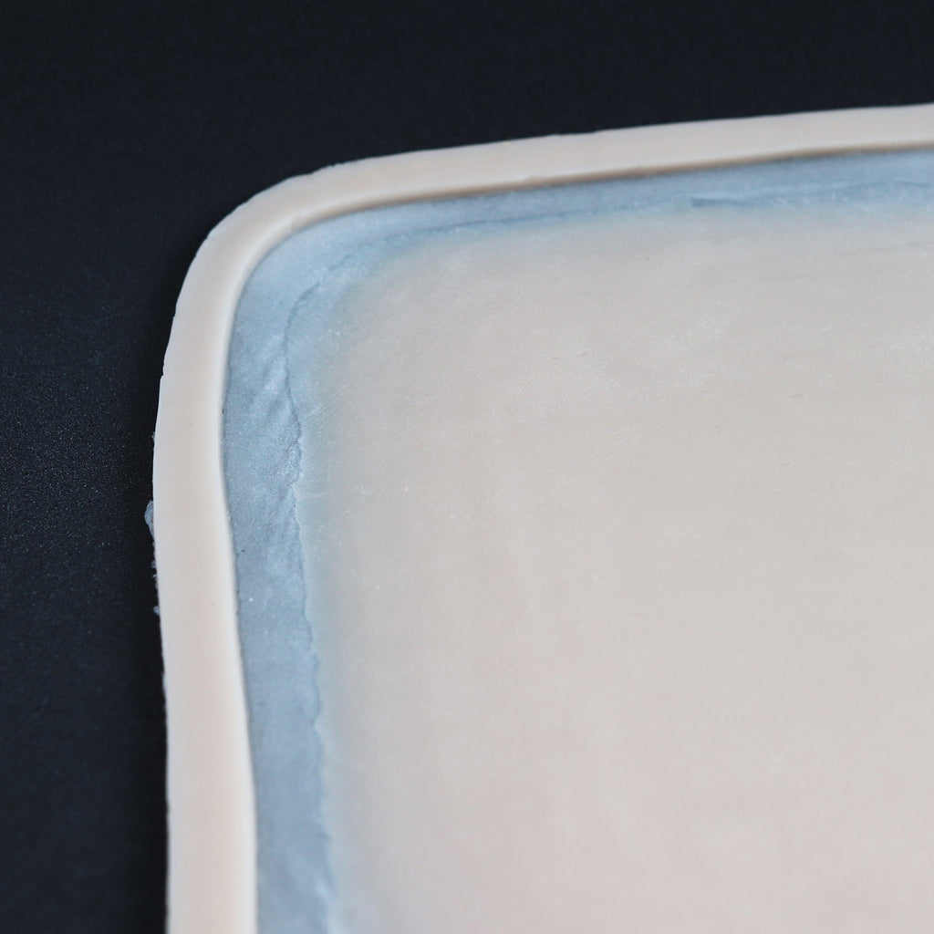 Regular Silicone Patch - Silicone makeup prosthetic in vanilla shade on a black surface