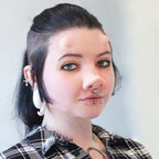 Woman with black hair wearing subdermal horns and a piglet nose prosthetic