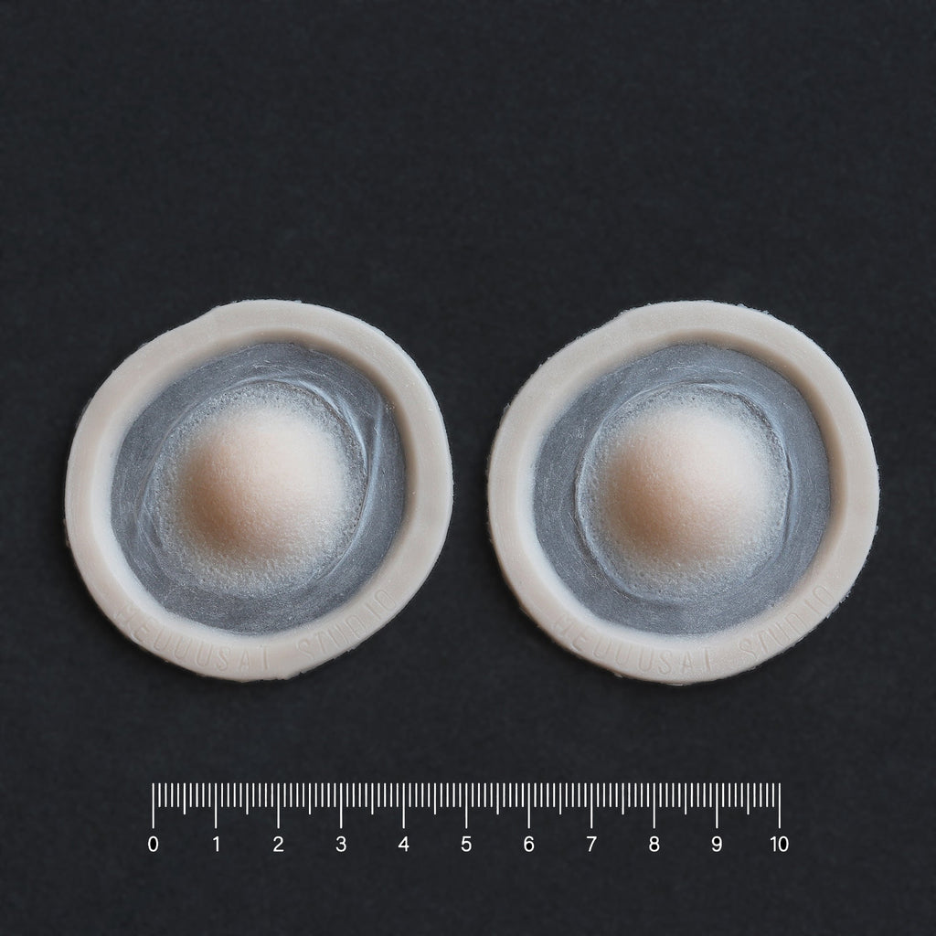 Single Subdermal Horns (Pair) - Silicone makeup prosthetic in vanilla shade on a black surface with a ruler