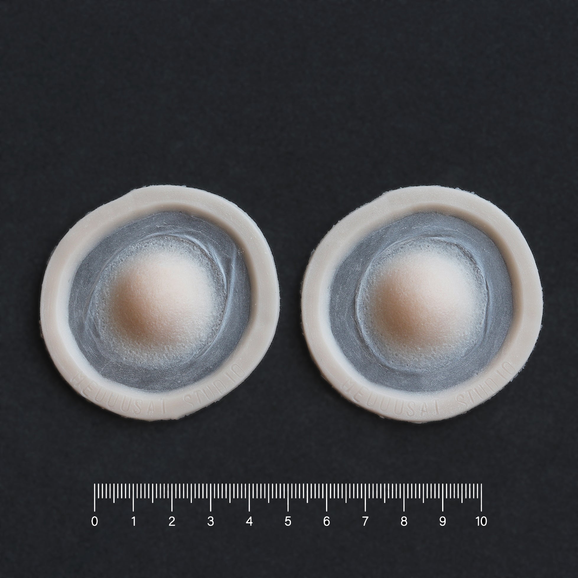 Single Subdermal Horns (Pair) - Silicone makeup prosthetic in vanilla shade on a black surface with a ruler