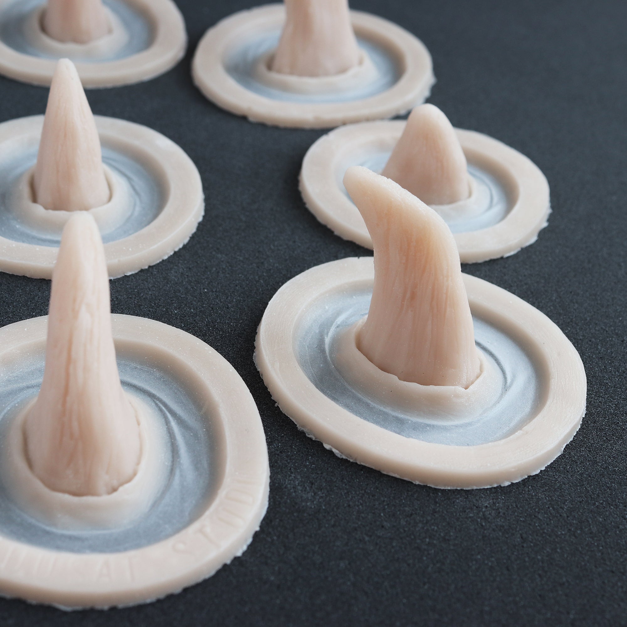 Small Horns Set - Silicone makeup prosthetic in vanilla shade on a black surface