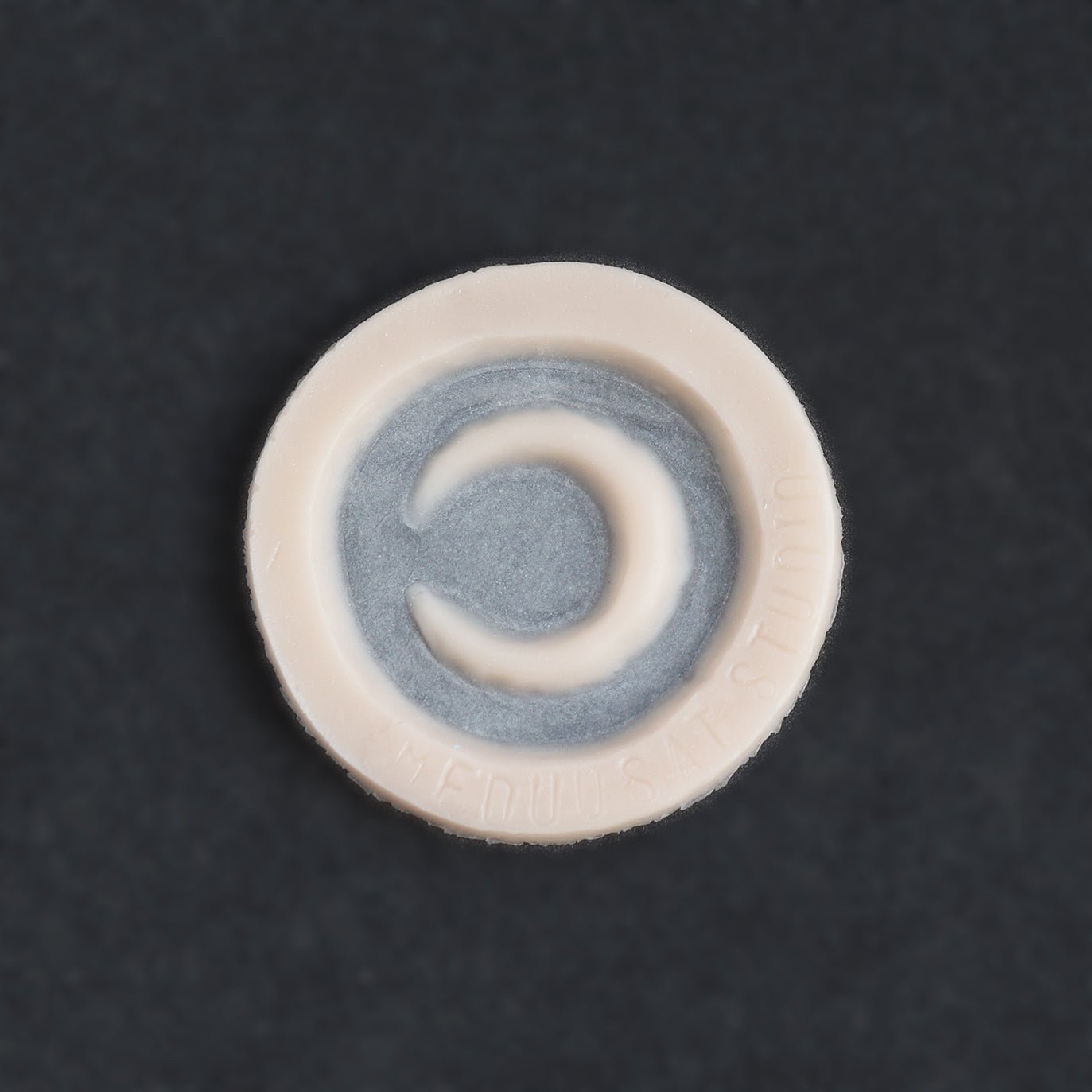 Small Moon - Silicone makeup prosthetic in vanilla shade on a black surface