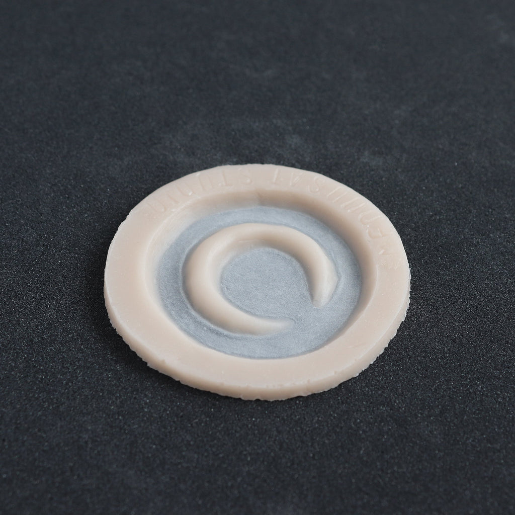 Small Moon - Silicone makeup prosthetic in vanilla shade on a black surface