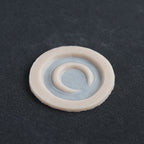 Small Moon - Silicone makeup prosthetic in vanilla shade on a black surface