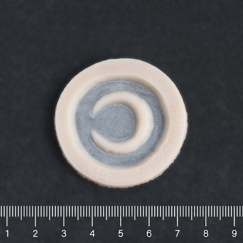 Small Moon - Silicone makeup prosthetic in vanilla shade on a black surface with a ruler