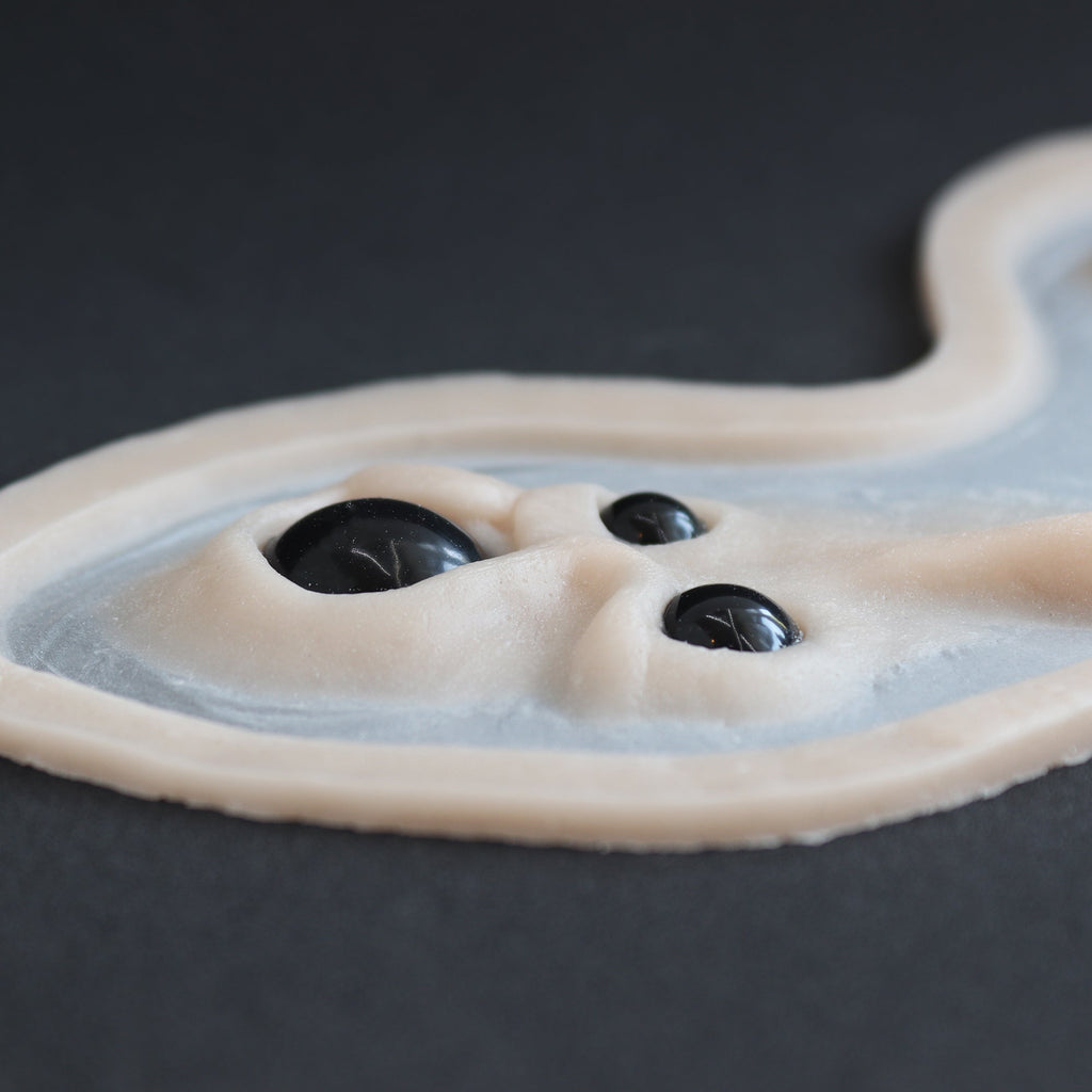 Spider Eyes - Silicone makeup prosthetic in vanilla shade on a black surface