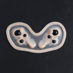 Spider Eyes - Silicone makeup prosthetic in vanilla shade on a black surface