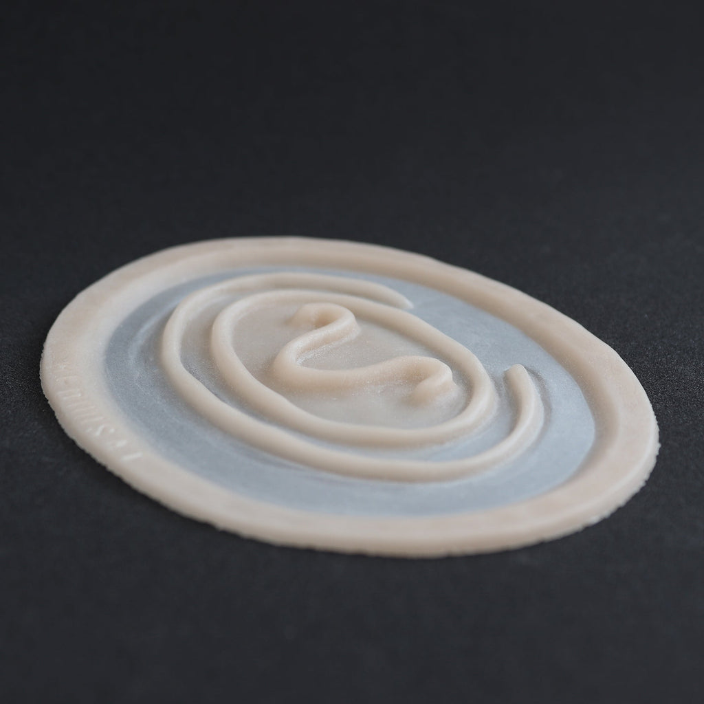 Stargate Goa'uld Mark - Silicone makeup prosthetic in vanilla shade on a black surface