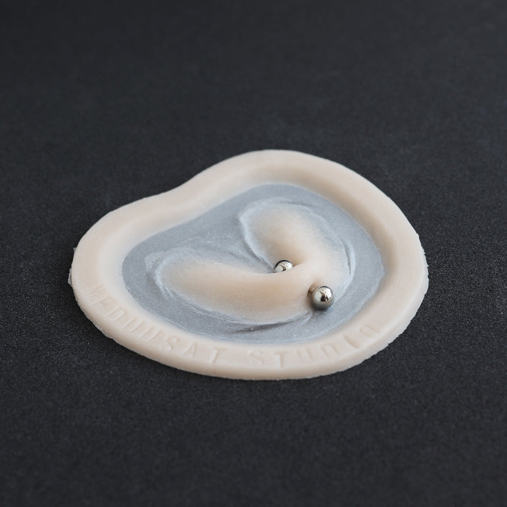 Stretched Piercing - Silicone makeup prosthetic in vanilla shade on a black surface