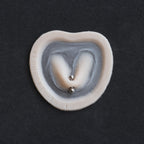 Stretched Piercing - Silicone makeup prosthetic in vanilla shade on a black surface