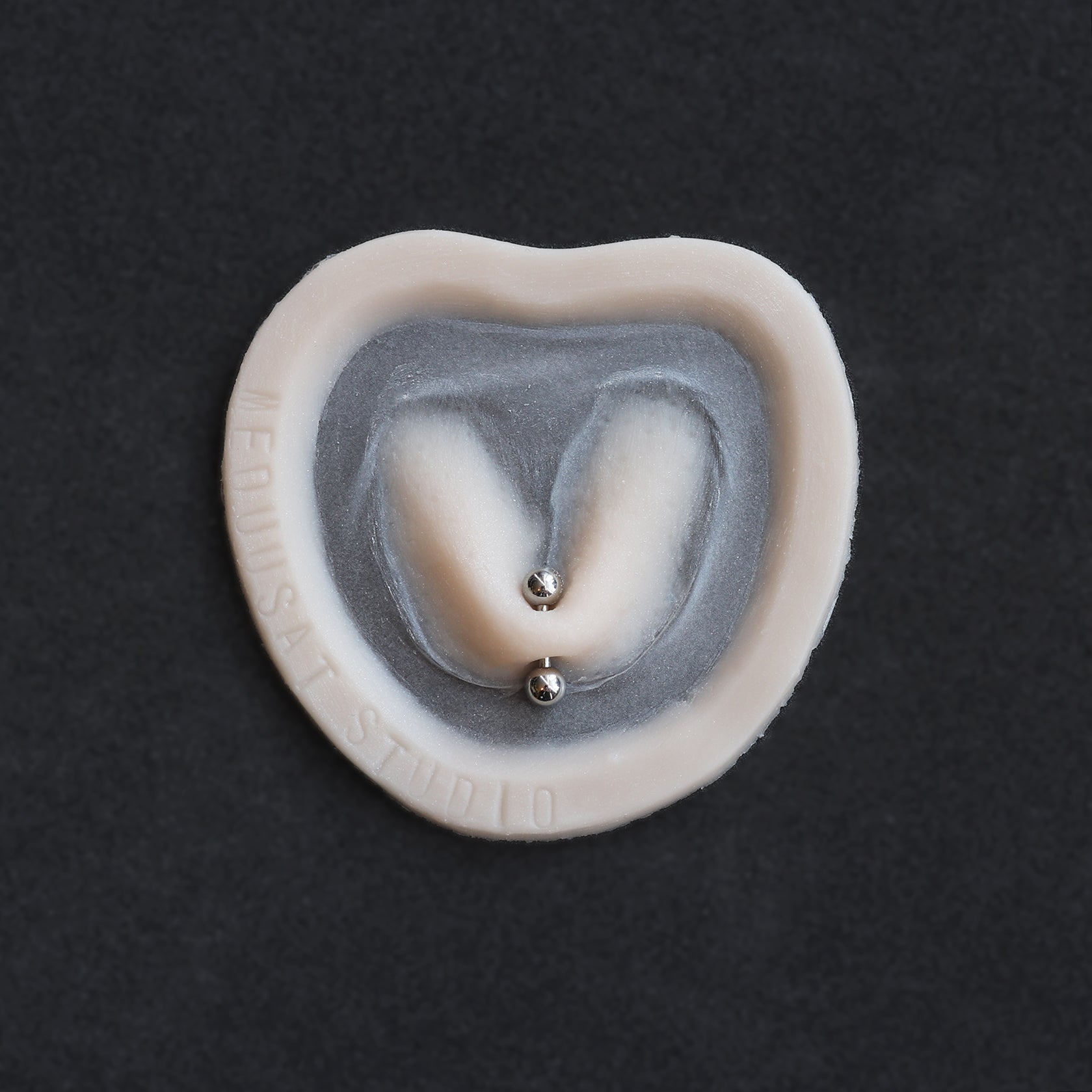 Stretched Piercing - Silicone makeup prosthetic in vanilla shade on a black surface