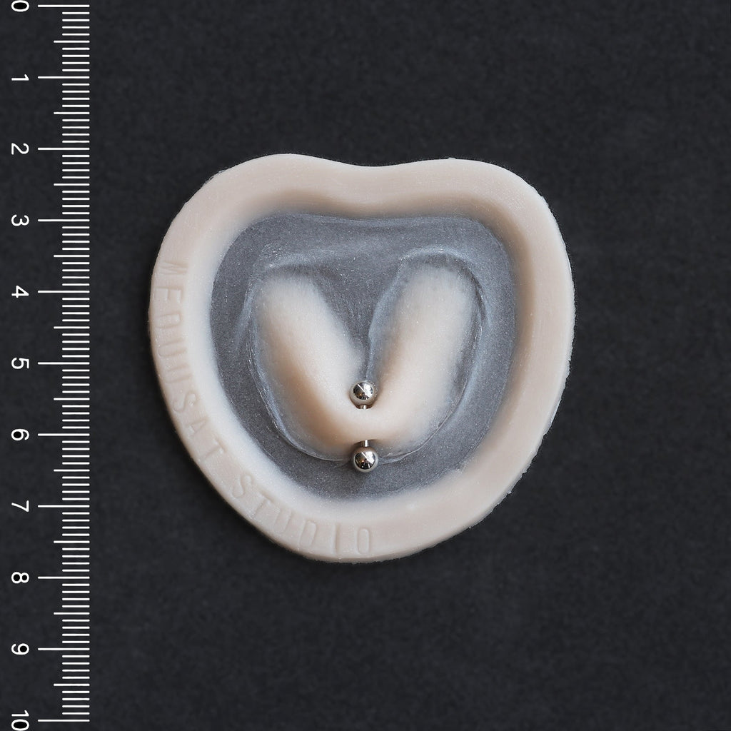 Stretched Piercing - Silicone makeup prosthetic in vanilla shade on a black surface with a ruler