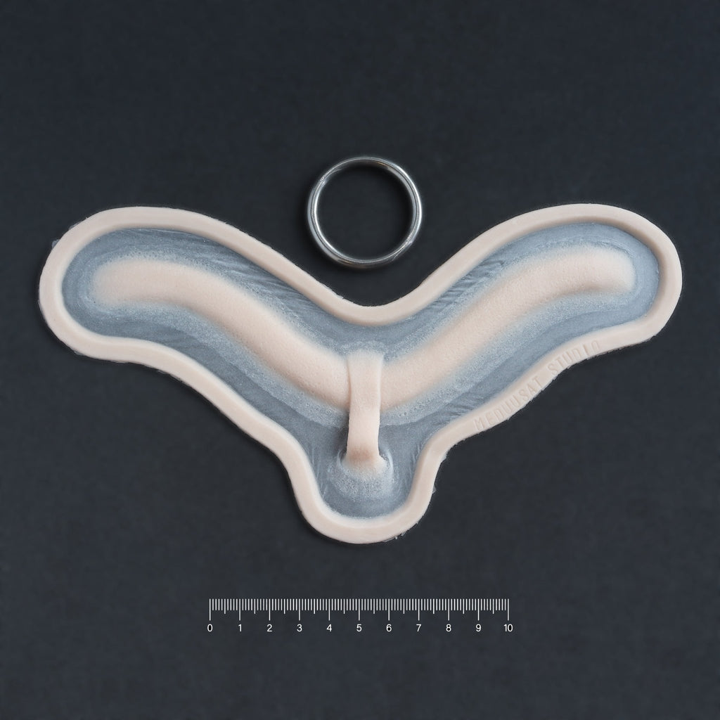 Subdermal Choker - Silicone makeup prosthetic in vanilla shade on a black surface with a ruler