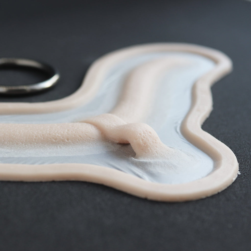 Subdermal Choker - Silicone makeup prosthetic in vanilla shade on a black surface