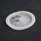 Surface Piercing - Silicone makeup prosthetic in vanilla shade on a black surface