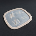 Tally Marks - Silicone makeup prosthetic in vanilla shade on a black surface