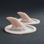 Torn Horns (Pair) - Silicone makeup prosthetic in vanilla shade on a black surface