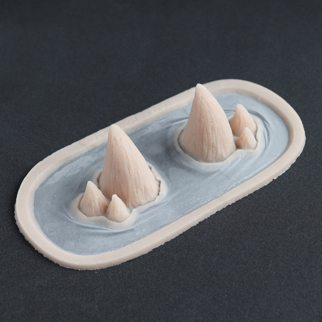 Triple Devil Horns - Silicone makeup prosthetic in vanilla shade on a black surface